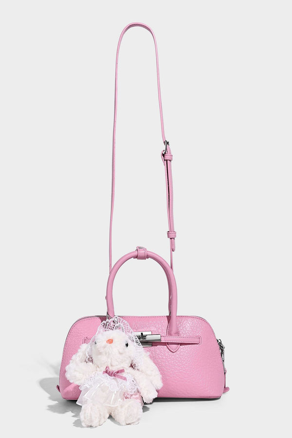 Small structured shell-silhouette top-handle bag with pebbled leather-look finish, silver-tone turn-lock hardware, and