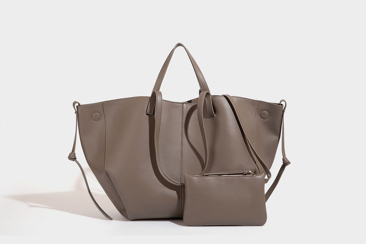 Große, formstabile trapezförmige Tote-Bag aus braunem Lederimitat mit genarbter Oberfläche, zwei Tragegriffen und seitlichen Bindebändern, Detail
