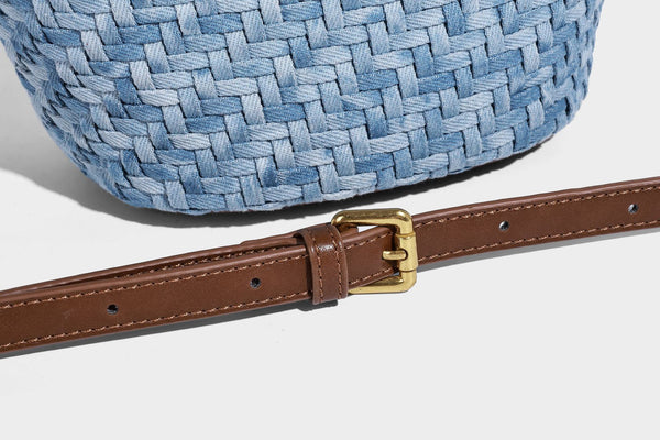 Blaue gewebte Bucket-Bag in Denim-Optik mit Besatz in brauner Lederoptik, rundem Henkel, Quastenanhänger mit Holzperlen und verstellbarem