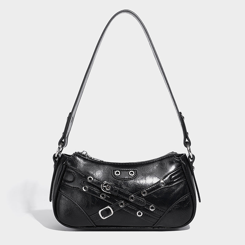 Compact moto-inspired shoulder bag with crisscross grommet strap detail, glossy textured finish, and adjustable crossbody