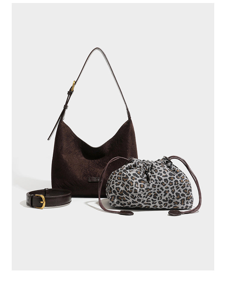 Dunkelbraune, lässig fallende Hobo-Schultertasche mit velourslederähnlich strukturierter Oberfläche, glatter lederähnlicher Paspelierung und Details in Antikgoldoptik, Detailansicht