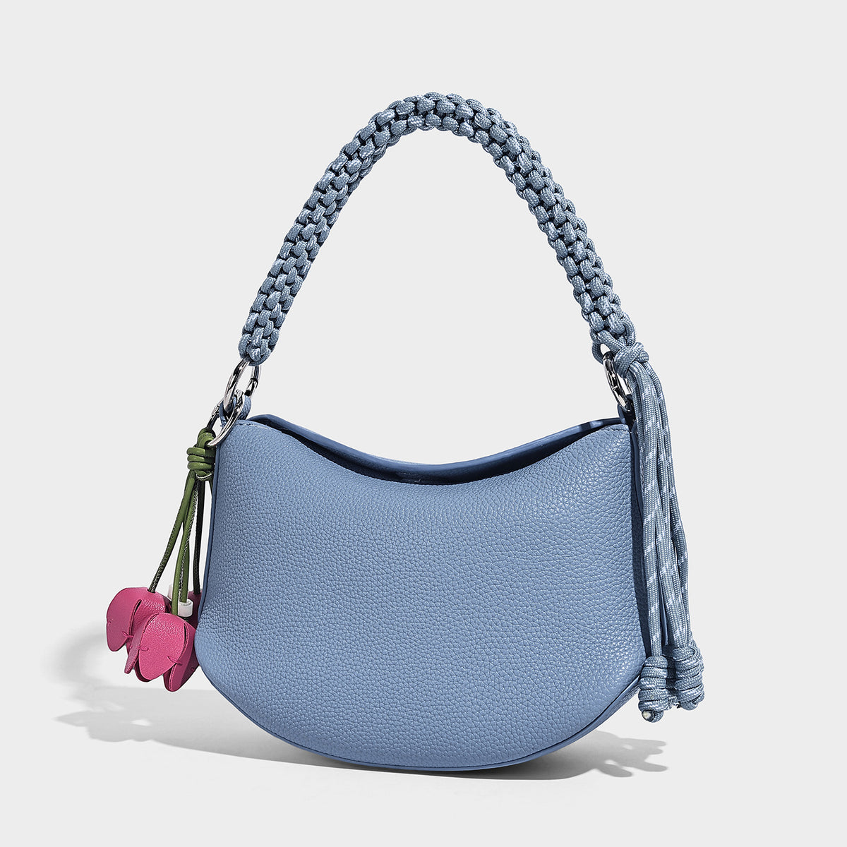Small crescent half-moon bag in pebbled leather-look finish with braided top handle, silver-tone ring hardware, and, front
