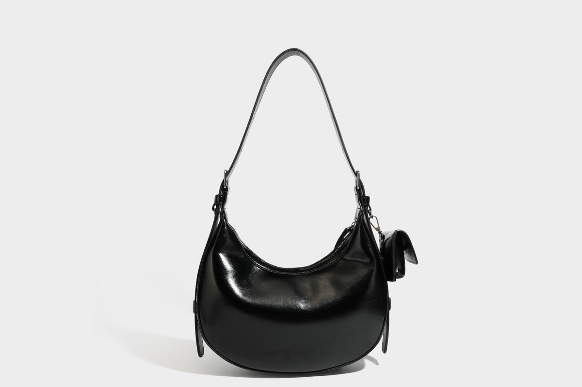 Glossy leather-look crescent hobo shoulder bag with dark contrast trim, silver-tone hardware, and attached mini flap pouch