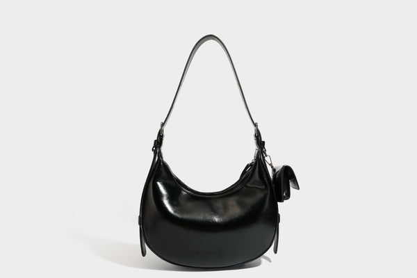 Glossy leather-look crescent hobo shoulder bag with dark contrast trim, silver-tone hardware, and attached mini flap pouch