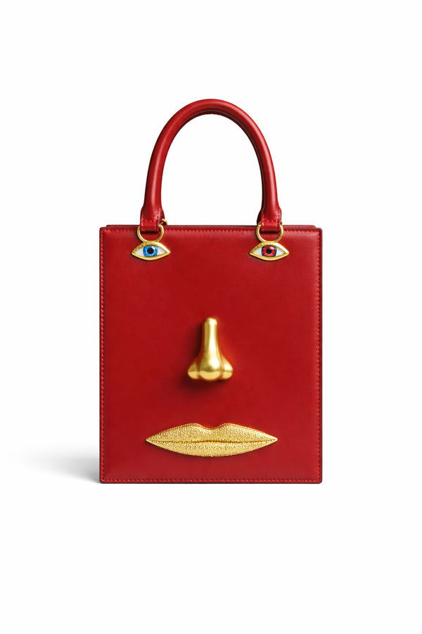 Structured rectangular top-handle bag in tan leather-look finish with gold-tone sculptural face hardware including