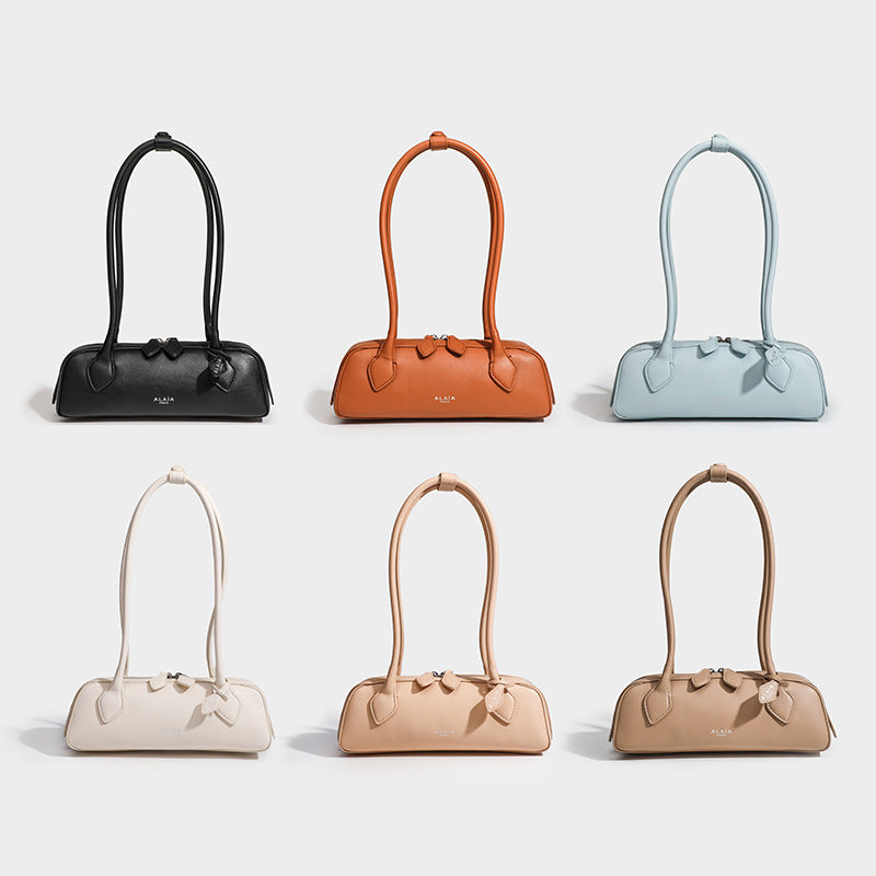 Structured baguette shoulder bag with smooth matte leather-look finish, long double straps, and top zipper closure, detail