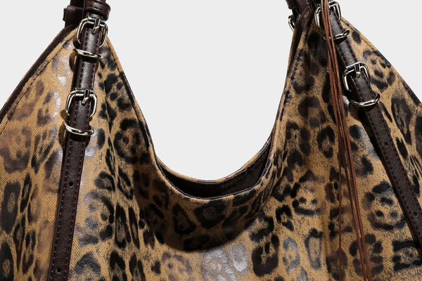 Slouchy leopard-print shoulder tote bag in tan and brown with long double straps, side tie straps, and dangling charm, detail