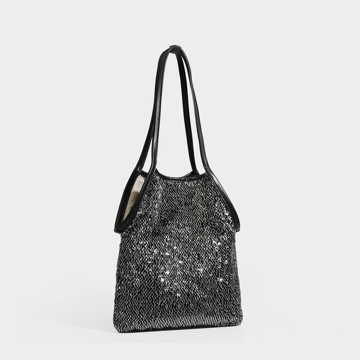 Small sequin shoulder tote bag with long metallic strap and trapezoid silhouette, front view