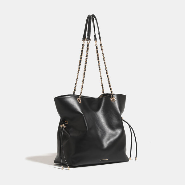 Soft-structured leather-look tote bag with gold-tone chain-and-strap shoulder handles and side drawstring cinches, detail