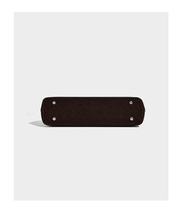 Structured trapezoid shoulder tote in dark brown matte suede-look finish with dual straps, wraparound belt bands