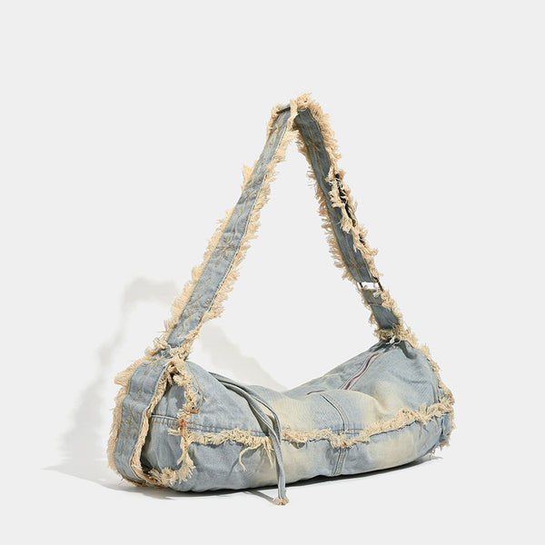 Large slouchy washed denim shoulder bag with frayed raw-edge trim and zip-top closure, detail view 2