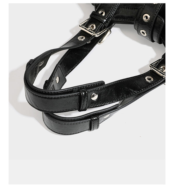 Large black glossy leather-look tote bag with silver buckle straps, eyelet grommet panels, drawstring side gathers, and