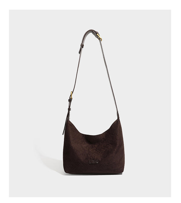 Dunkelbraune, lässig fallende Hobo-Schultertasche mit velourslederähnlich strukturierter Oberfläche, glatter lederähnlicher Paspelierung und Details in Antikgoldoptik, Detailansicht