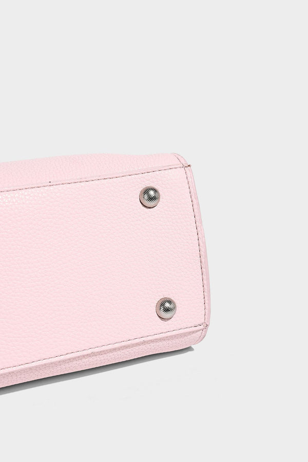 Small structured pebbled-finish shoulder bag with braided top handle, detachable crossbody strap, floral tassel charm, and
