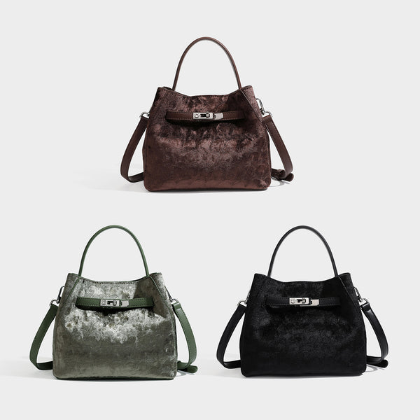 Small structured bucket satchel in embossed velvet-texture fabric with silver turn-lock hardware, rounded top handle, and