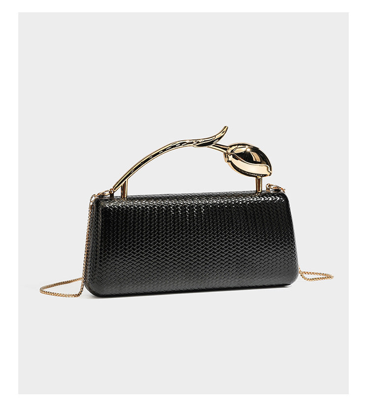Structured rectangular metallic woven clutch bag with sculptural gold-tone leaf top handle and detachable chain strap, detail