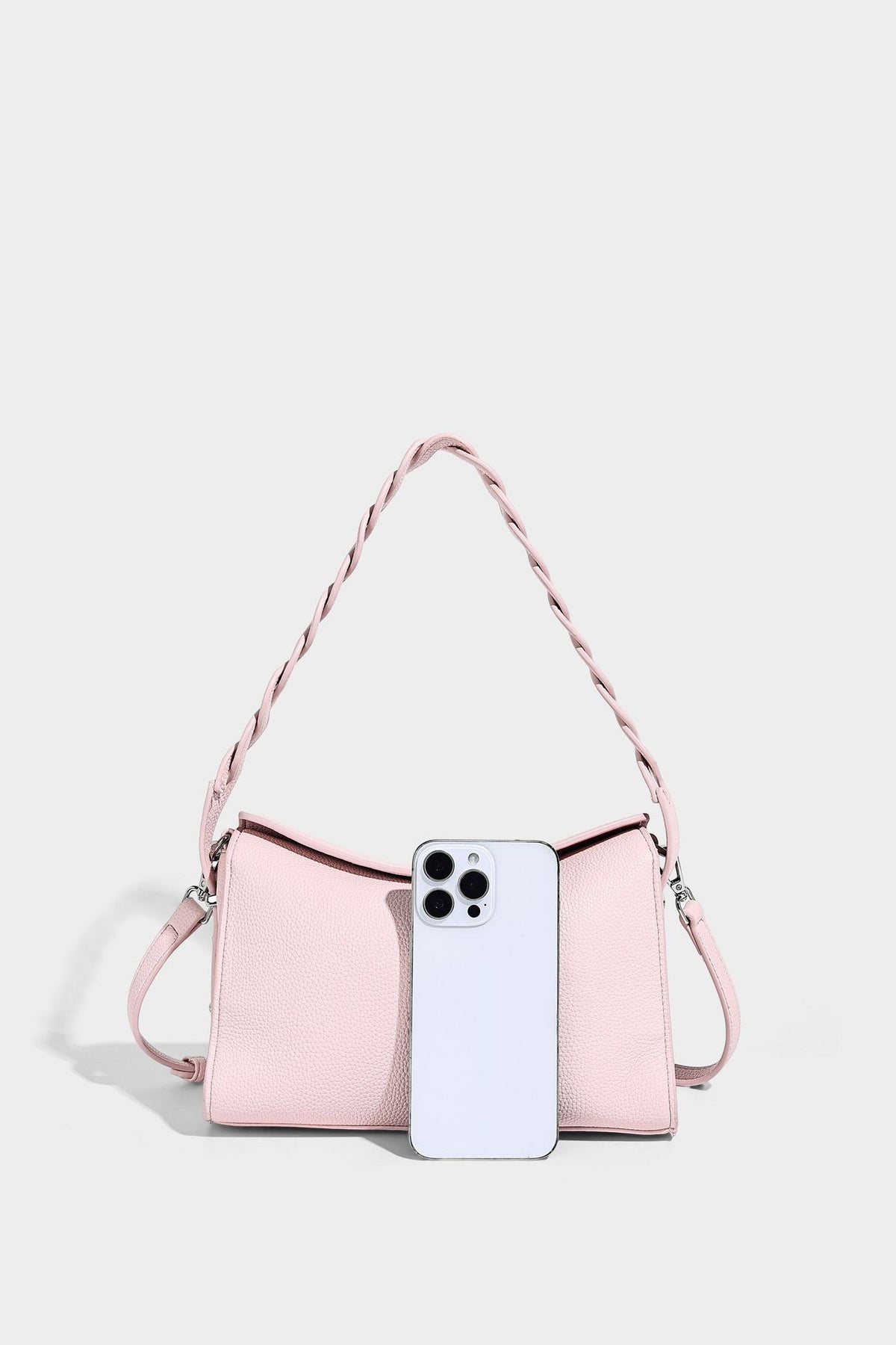 Small structured pebbled-finish shoulder bag with braided top handle, detachable crossbody strap, floral tassel charm, and