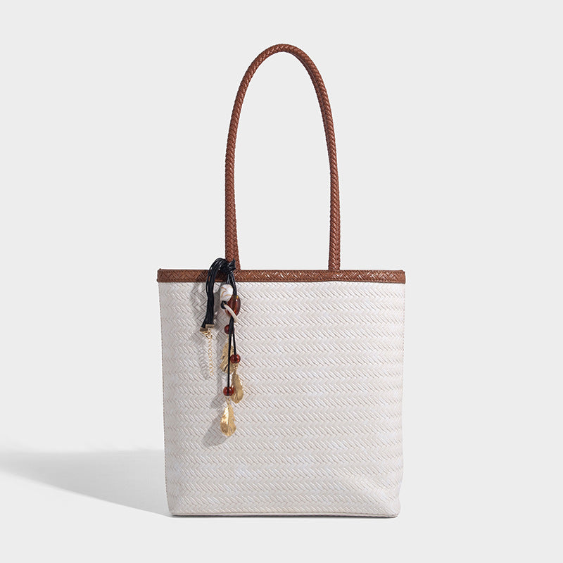 Structured woven herringbone tote bag with braided double shoulder handles in tan brown, shown with matching drawstring