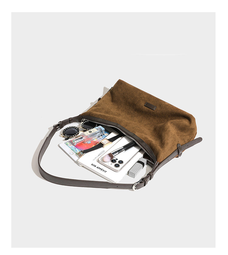 Lässige Hobo-Schultertasche mit matter brauner Wildlederoptik, dunklen glatten Besätzen, Reißverschluss oben und langem, verstellbarem