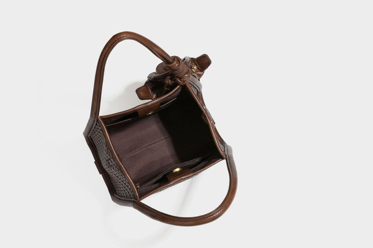 Strukturierte Tote-Bag mit Webstruktur in Braun, glattem Besatz in Lederoptik, geknoteten Henkeln und angehängtem Mini-Beutel mit Kordelzug