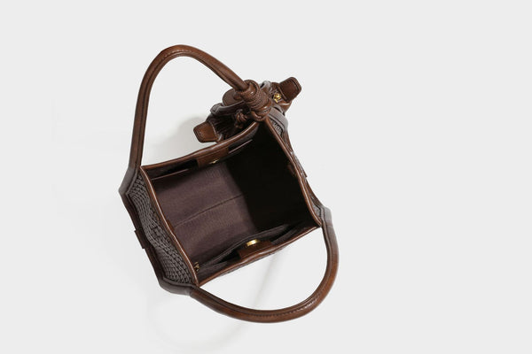 Strukturierte Tote-Bag mit Webstruktur in Braun, glattem Besatz in Lederoptik, geknoteten Henkeln und angehängtem Mini-Beutel mit Kordelzug