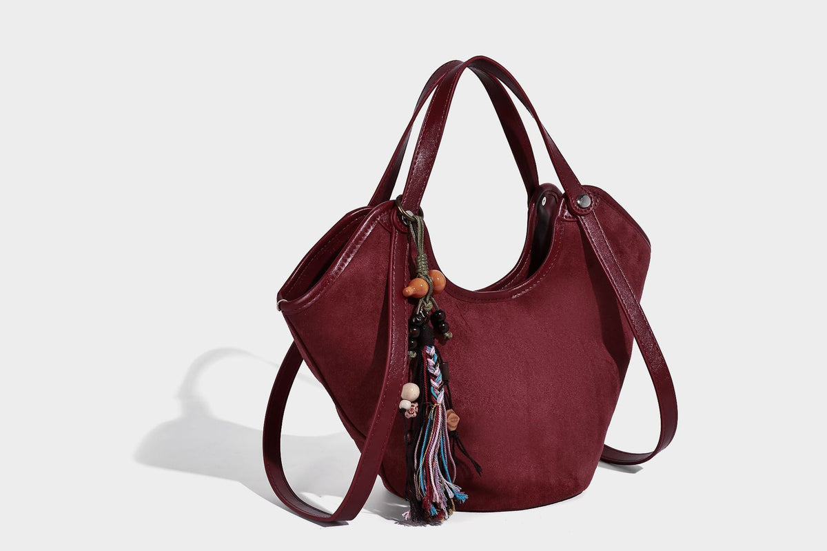 Dunkelbraune matte Hobo-Schultertasche in Velourslederoptik mit geschwungener, oben offener Silhouette, zwei Schulterriemen und abnehmbarem