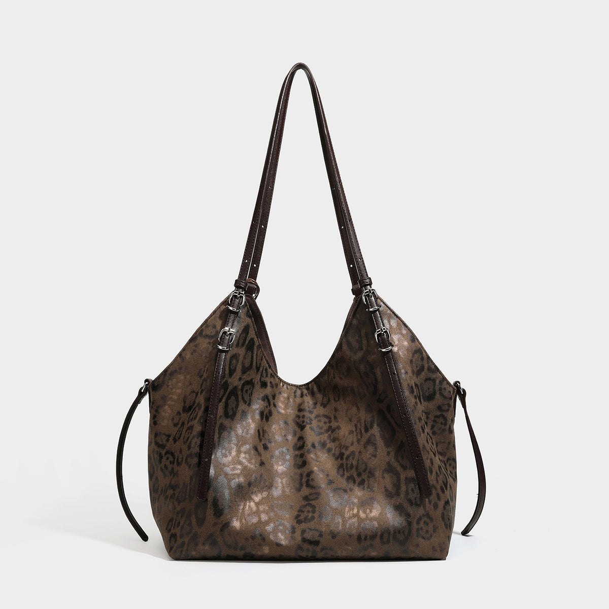 Slouchy leopard-print shoulder tote bag in tan and brown with long double straps, side tie straps, and dangling charm, detail