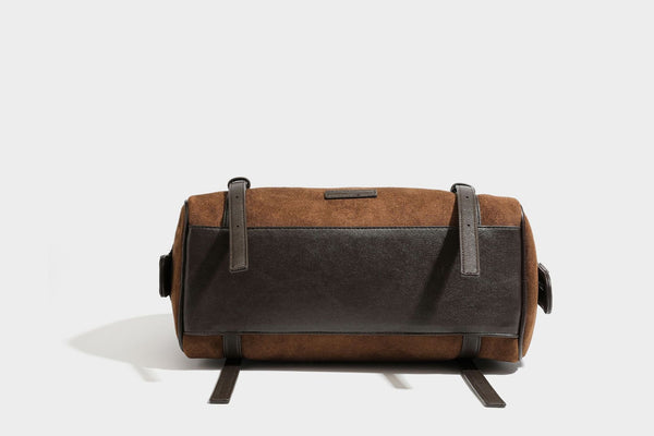 Large brown suede-finish barrel shoulder bag with dark leather-look trim, silver-tone zippers, dual top handles, and long