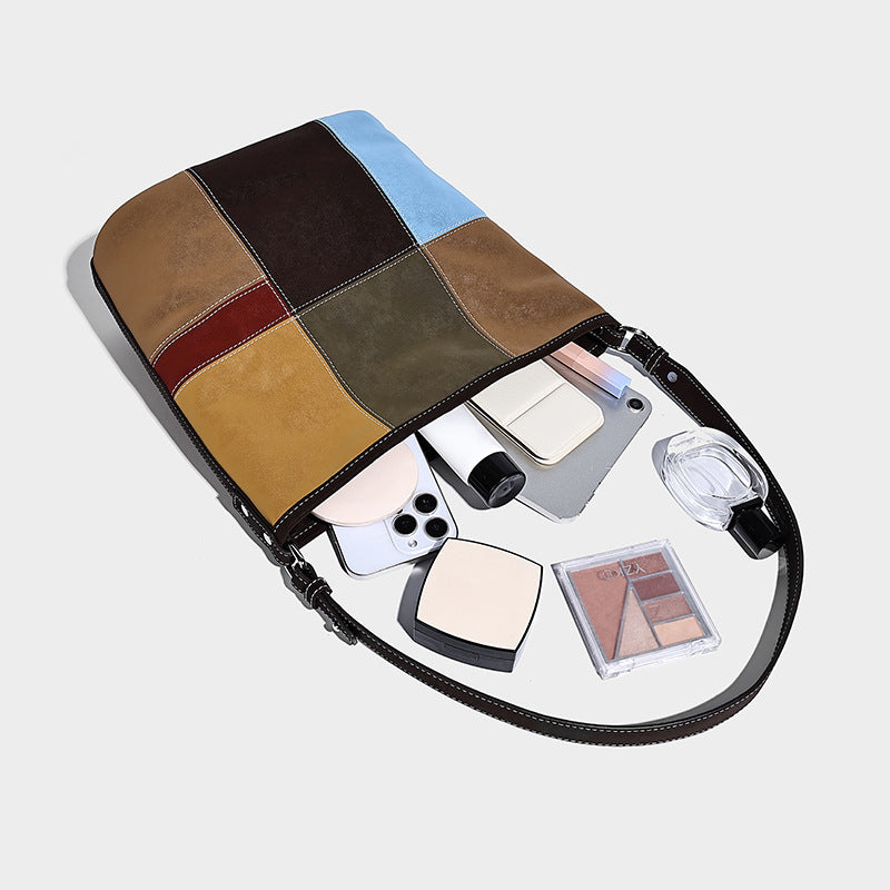 Lässig weich fallende Patchwork-Beuteltasche mit dunkelbraunen, cognacfarbenen, senfgelben, olivgrünen, roten und hellblauen Einsätzen sowie Kontrastnähten