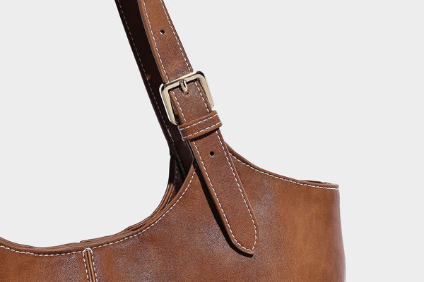 Große, strukturierte Schultertasche im Tote-Stil in Braun und Lederoptik mit langen Doppelriemen, Schnallenbeschlägen, Quasten-Anhänger und geschwungener