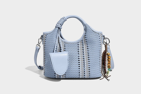 Geflochtene Bucket-Tote in Pastellblau mit geflochtenen Tragegriffen, vorderem Steckfach, Perlenanhänger und abnehmbarem Crossbody-Riemen