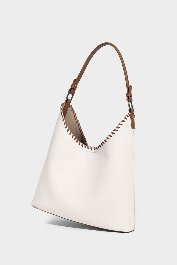 Denim-blue hobo tote with white leather-look shoulder strap, contrast whipstitch trim along curved open top, and silver-tone