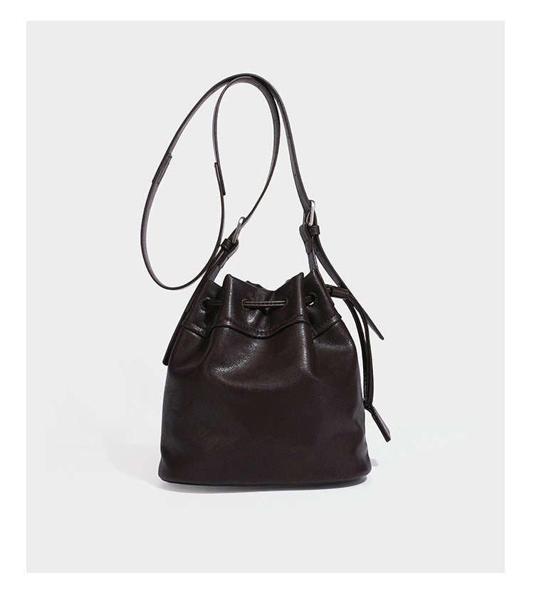 Kleine dunkelbraune Beuteltasche mit Kordelzug, langem verstellbarem Crossbody-Riemen und silberfarbenen Beschlägen, Detailansicht 14