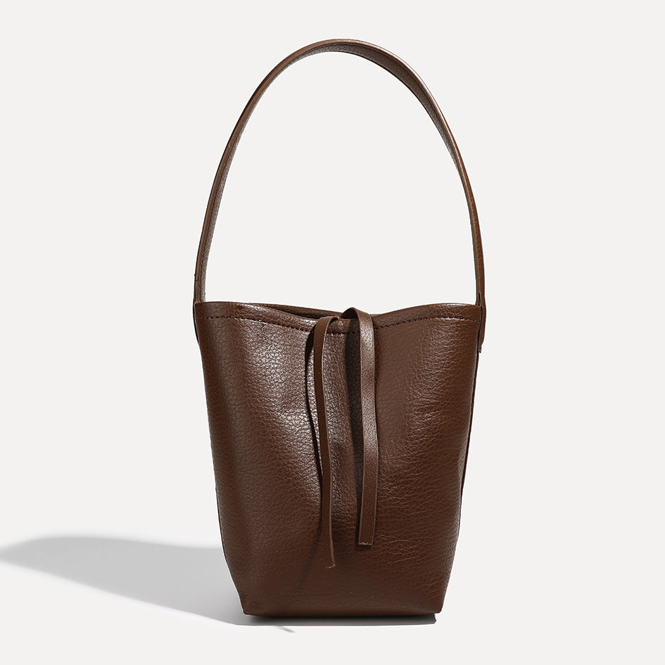 Mini tapered bucket bag in pebbled leather-look finish with front tie straps and single shoulder strap, detail view 11
