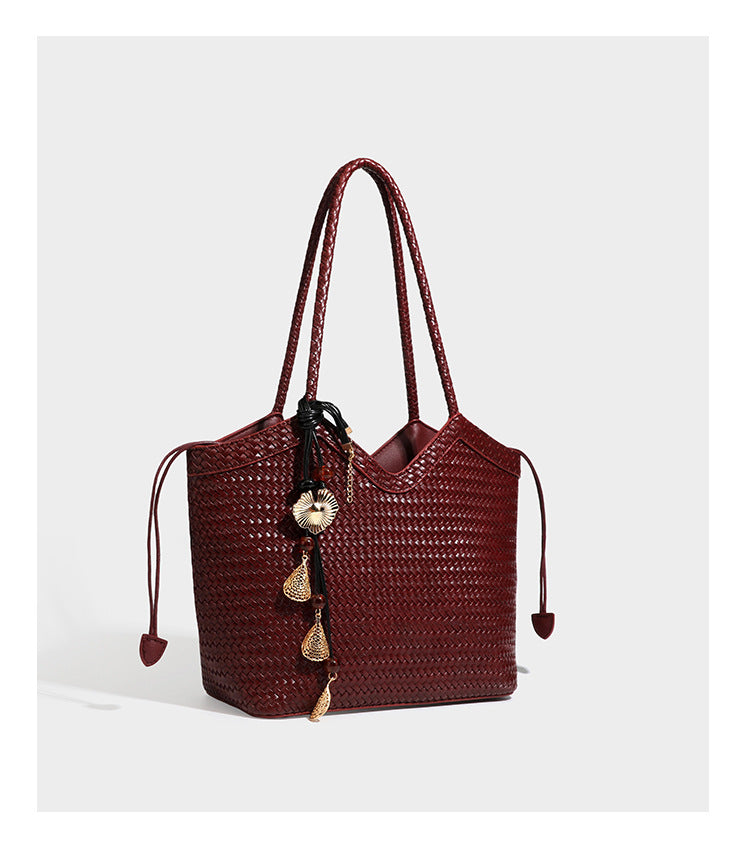 Woven tote bag with braided shoulder straps, drawstring closure, and dangling metal-and-bead charm, detail view 24