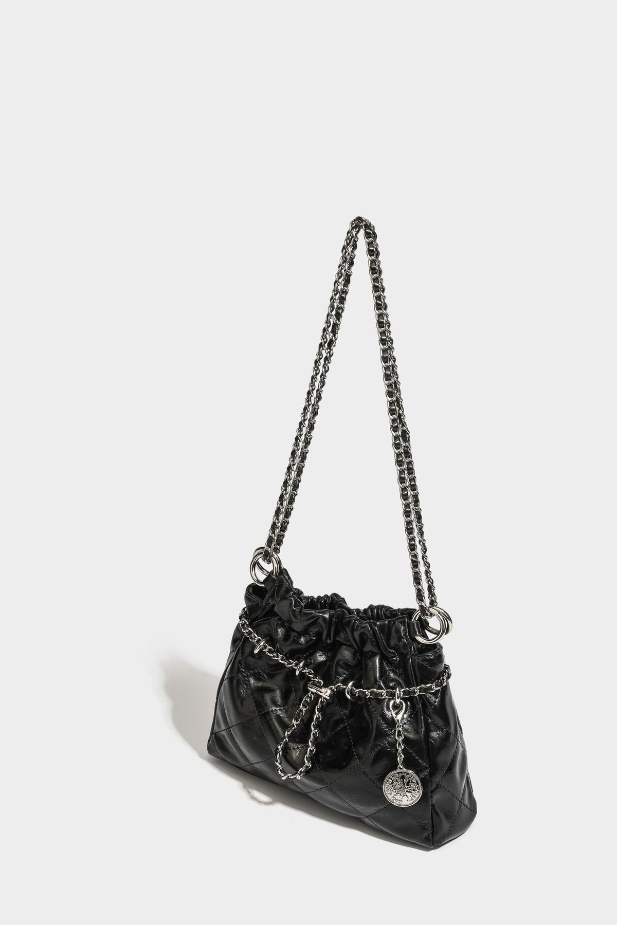 Glossy diamond-quilted drawstring bucket bag with silver chain shoulder strap and medallion charm, detail view 31