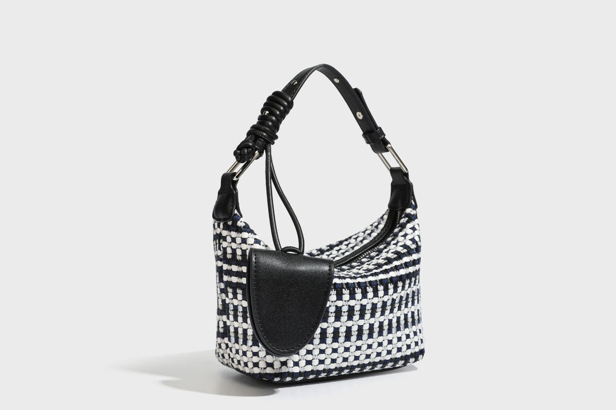 Small crescent shoulder bag in black-and-white woven textile with smooth black leather-look trim, zip-top closure, knotted