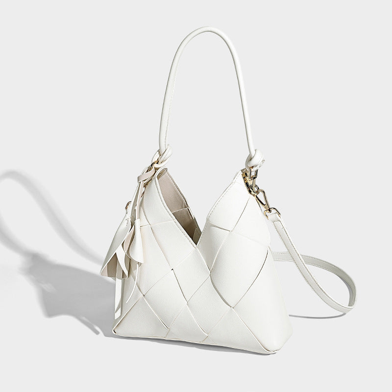 Compact bucket shoulder bag with black-and-white diamond patchwork panels, knotted top handle, gold-tone hardware, and