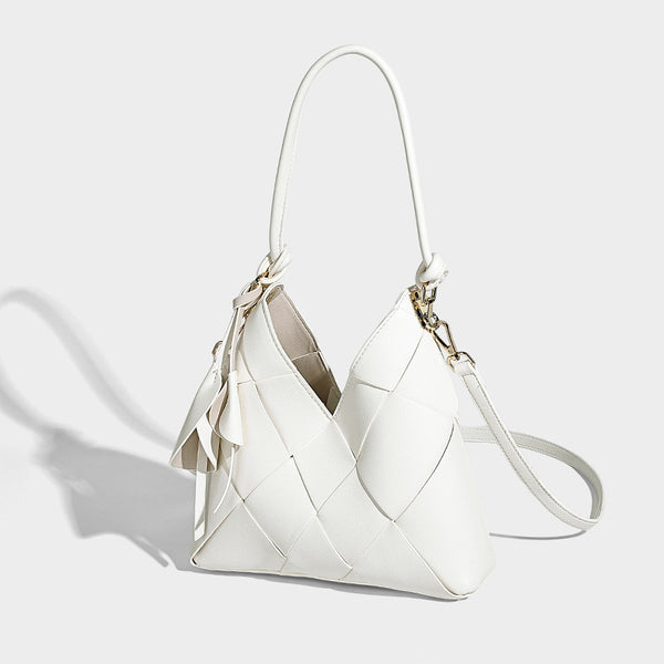 Compact bucket shoulder bag with black-and-white diamond patchwork panels, knotted top handle, gold-tone hardware, and