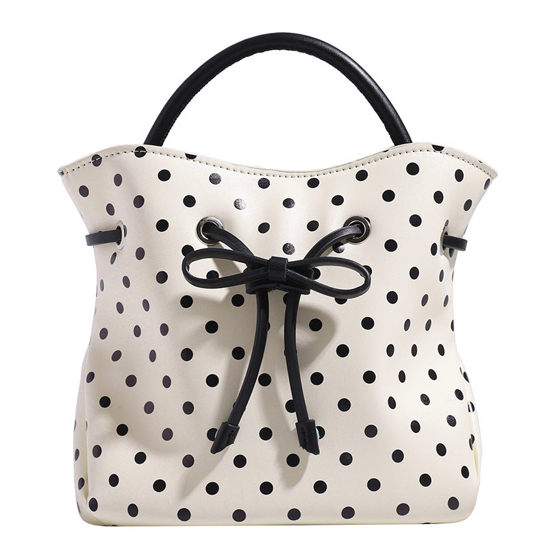 Compact polka-dot drawstring bucket bag with bow closure and rigid top handle, detail view 5