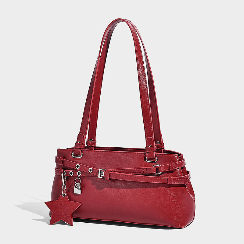 Structured glossy leather-look shoulder bag with wraparound belt straps, silver-tone hardware, and dangling star charm, front