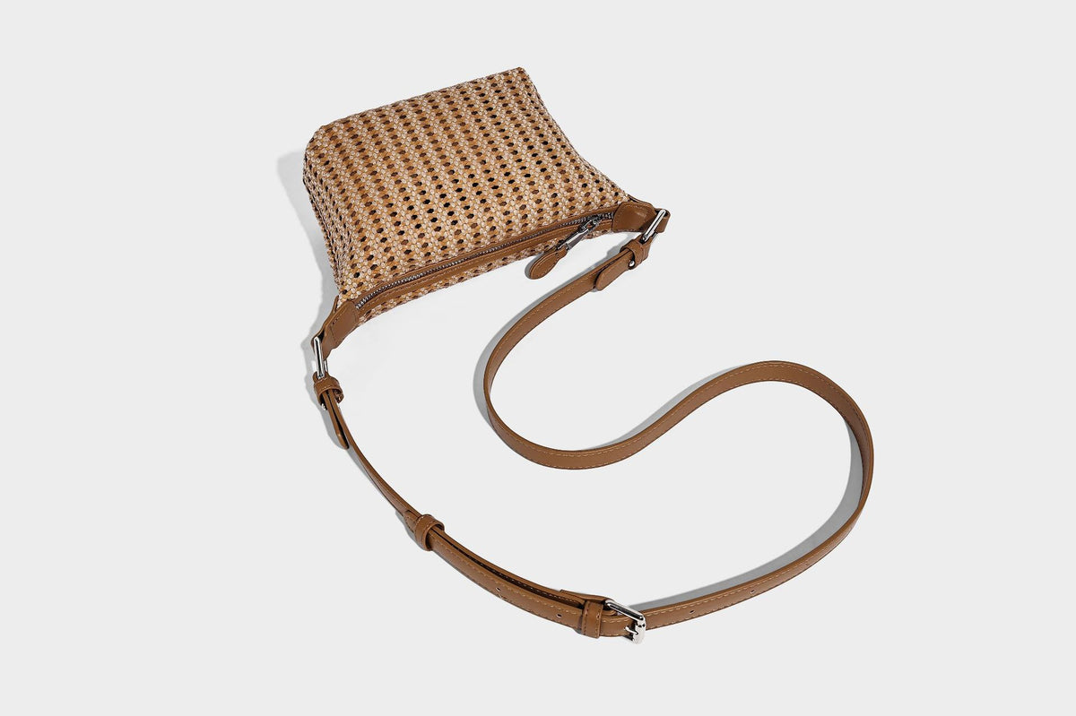 Woven crescent shoulder bag with leather-look knotted handle, zip top, attached mini pouch, and silver-tone hardware, detail