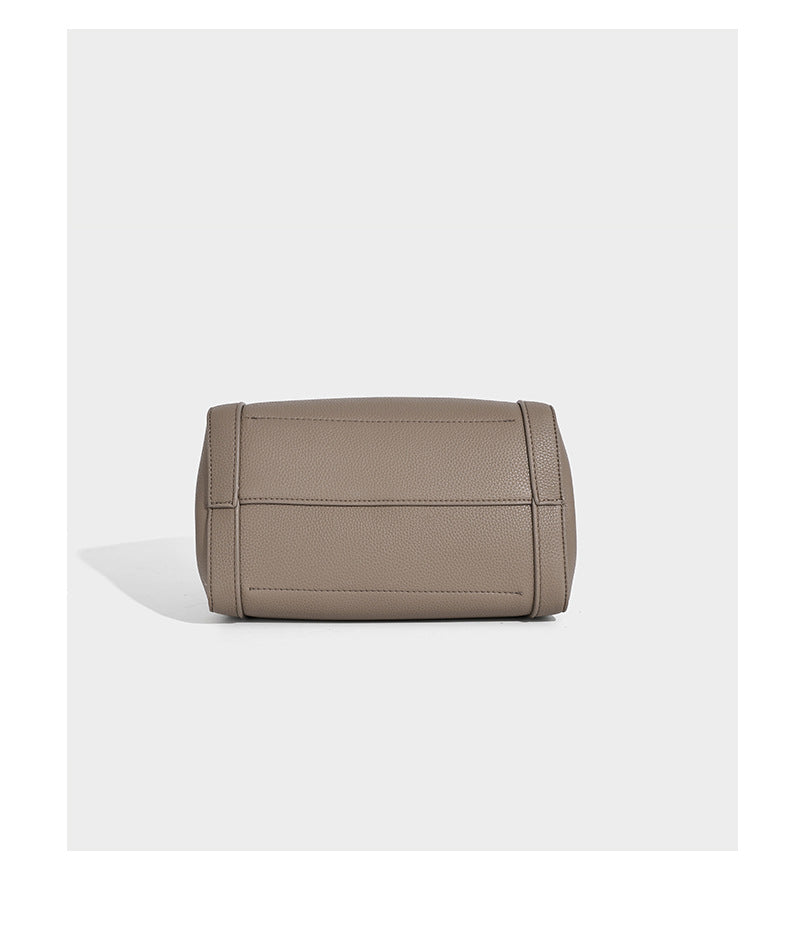 Structured trapezoid tote bag in taupe pebbled leather-look finish with gold-tone turn-lock hardware, dual top handles, and