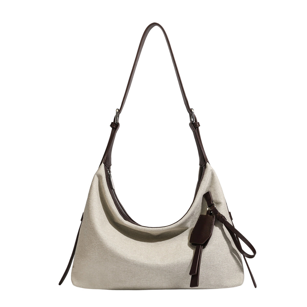 Cream canvas hobo shoulder bag with dark brown leather-look trim, zip-top closure, adjustable strap, and silver-tone