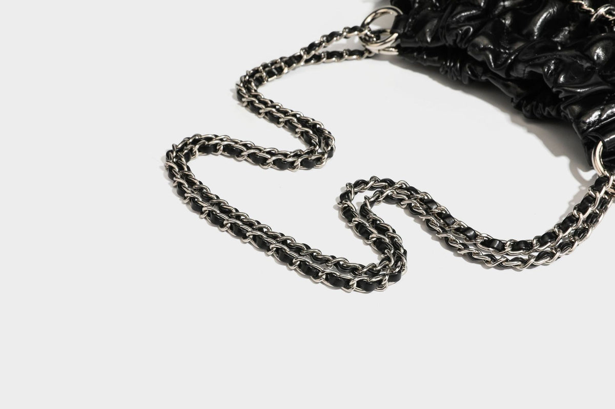 Glossy diamond-quilted drawstring bucket bag with silver chain shoulder strap and medallion charm, detail view 36