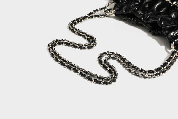 Glossy diamond-quilted drawstring bucket bag with silver chain shoulder strap and medallion charm, detail view 36