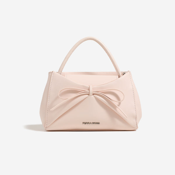 Small structured trapezoid handbag with a three-dimensional front bow, short top handle, and detachable shoulder strap