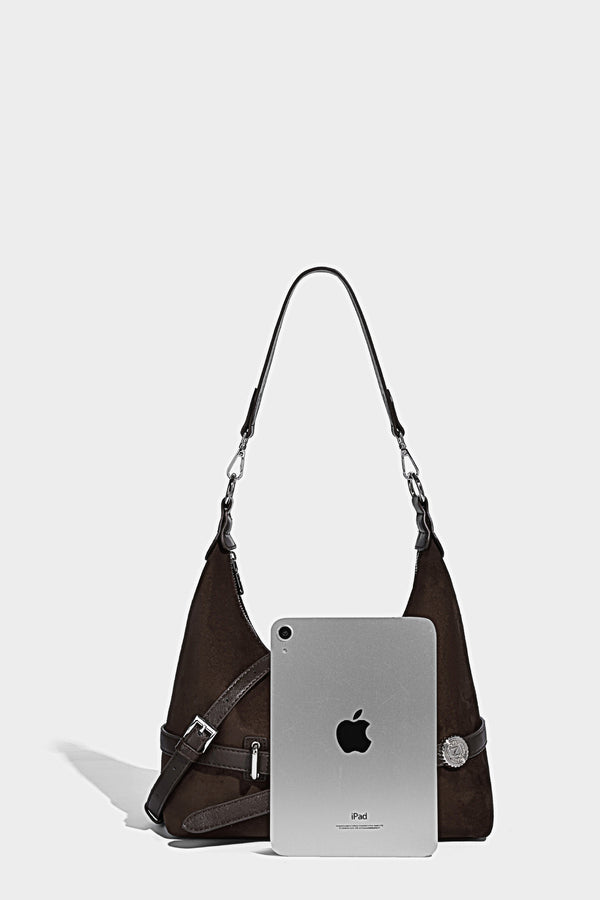 Hobo-Schultertasche in Dunkelbraun mit velourslederartiger Oberfläche, silberfarbener Gürtelschnalle und Ösenbeschlägen, verstellbarem Riemen, Detailansicht