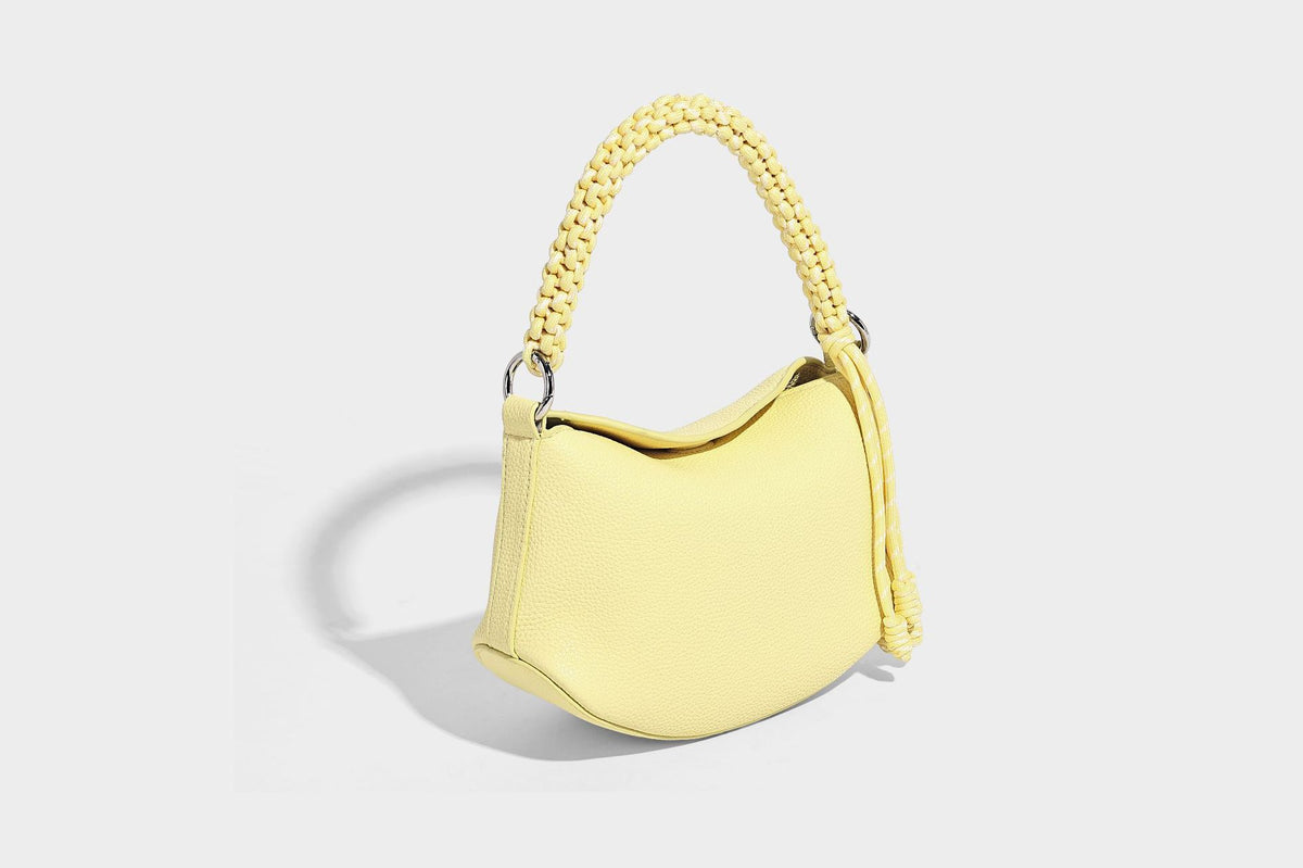 Small crescent half-moon bag in pebbled leather-look finish with braided top handle, silver-tone ring hardware, and, detail