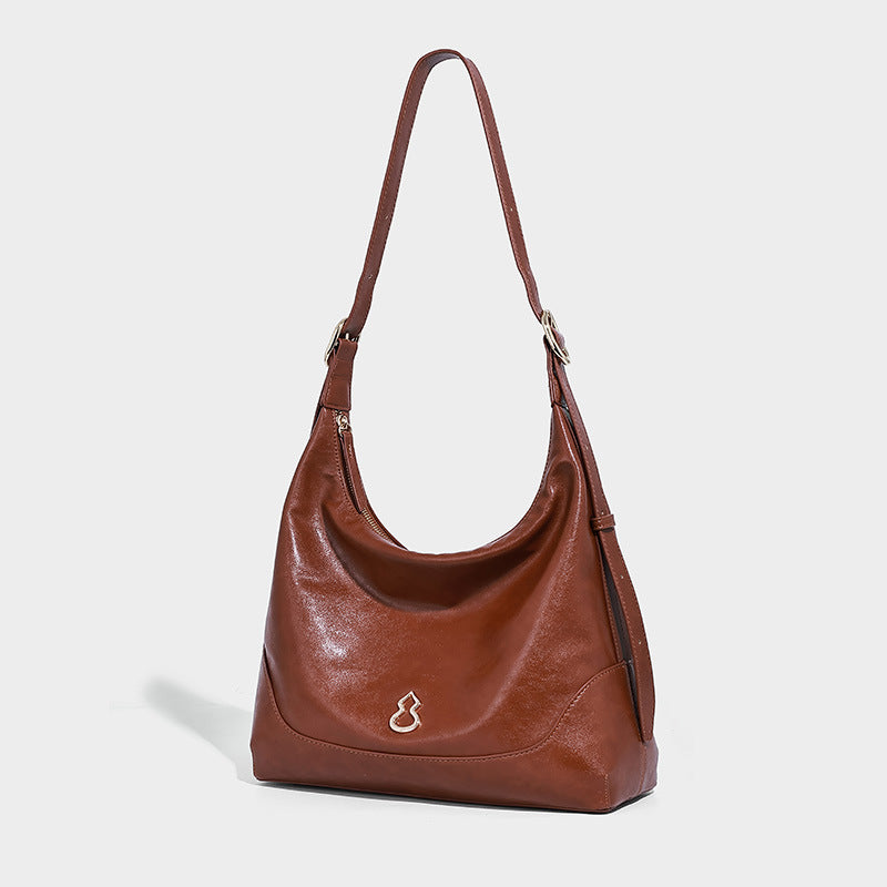 Glossy leather-look slouchy hobo shoulder bag with zip closure, gold-tone hardware, and adjustable strap, front view